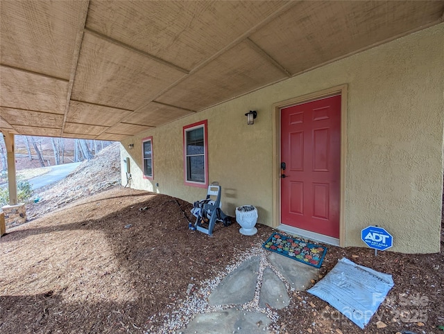 doorway to property featuring stucco siding