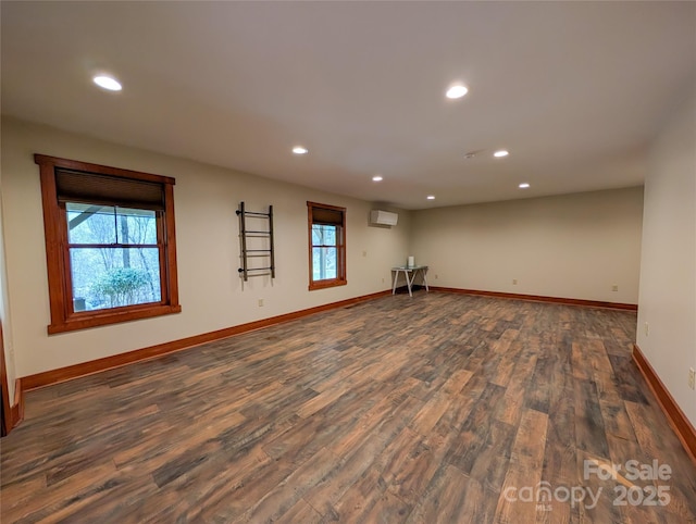 interior space with recessed lighting, a wall mounted air conditioner, dark wood finished floors, and baseboards