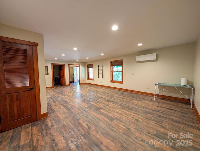 interior space featuring baseboards, an AC wall unit, recessed lighting, and wood finished floors
