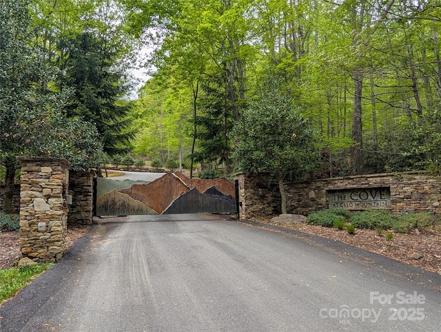 view of gate with a view of trees