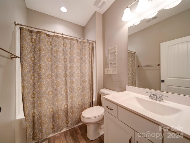 full bathroom with shower / tub combo with curtain, vanity, wood-type flooring, and toilet