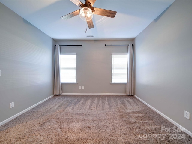 carpeted spare room featuring ceiling fan and a healthy amount of sunlight