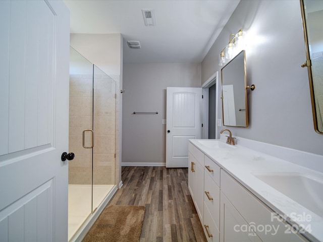 bathroom featuring walk in shower, vanity, and hardwood / wood-style flooring