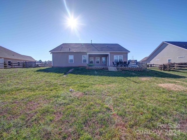 rear view of property featuring a yard