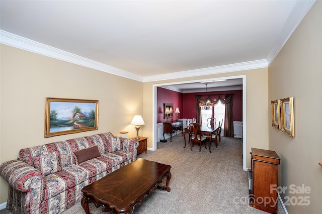 carpeted living room featuring crown molding and a chandelier