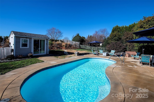 view of swimming pool featuring a patio area and an outdoor structure