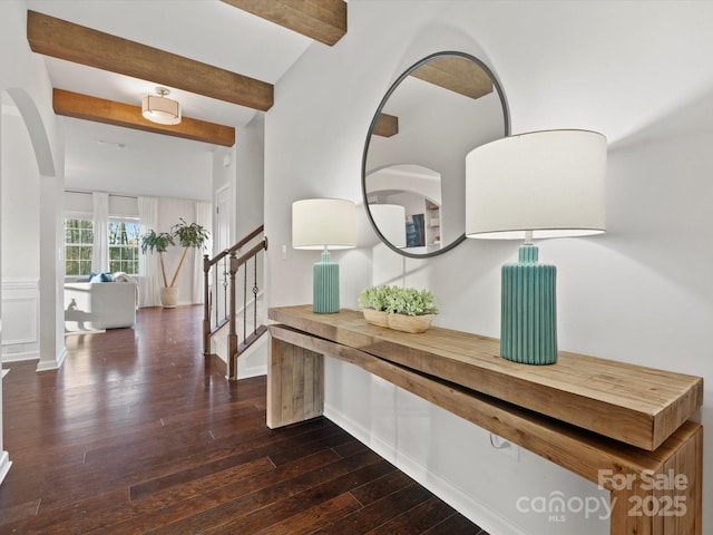 interior space featuring dark wood-type flooring and vaulted ceiling with beams