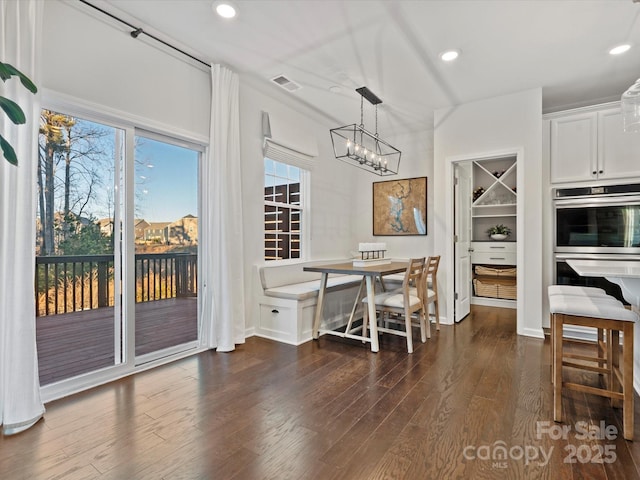 dining space with a chandelier and dark hardwood / wood-style flooring