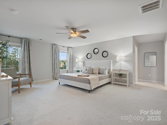 bedroom with multiple windows, light carpet, and ceiling fan