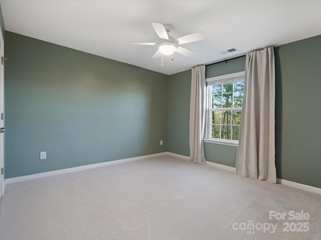 carpeted spare room featuring ceiling fan