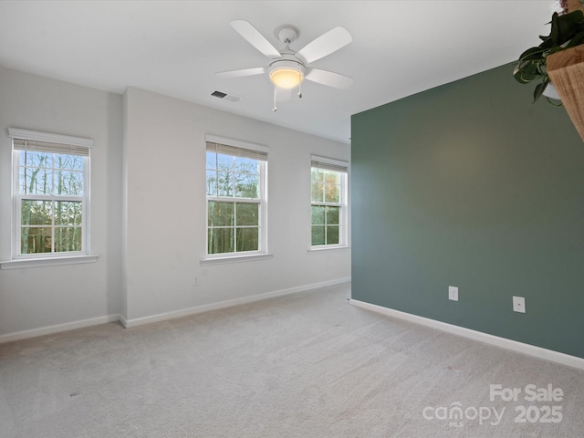 spare room with ceiling fan and light colored carpet