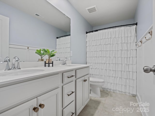 full bathroom featuring toilet, shower / tub combo with curtain, and vanity