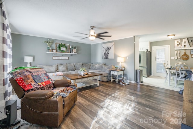 living room with ceiling fan, crown molding, and dark hardwood / wood-style floors