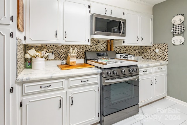 kitchen featuring tasteful backsplash, white cabinetry, and stove