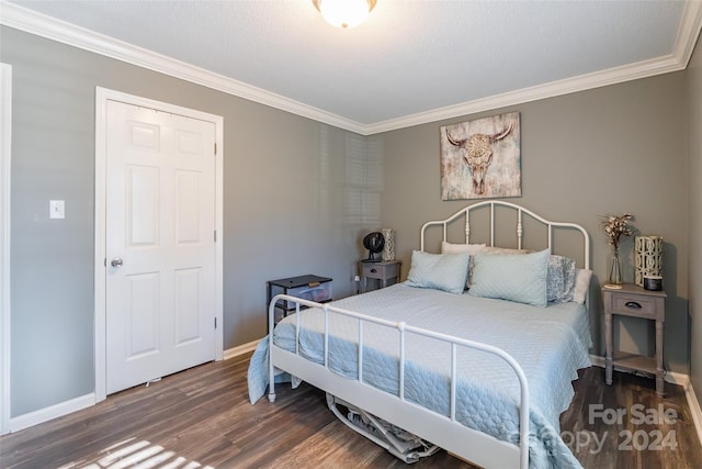 bedroom with dark hardwood / wood-style floors, ornamental molding, and a textured ceiling