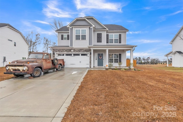 view of front of home featuring a front lawn, covered porch, driveway, and an attached garage