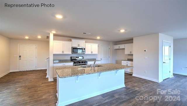 kitchen with sink, white cabinetry, stainless steel appliances, and a kitchen island with sink