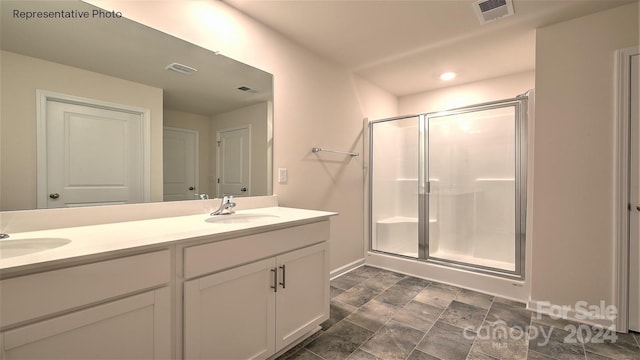 bathroom featuring vanity and an enclosed shower