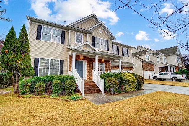 multi unit property featuring covered porch and a front yard