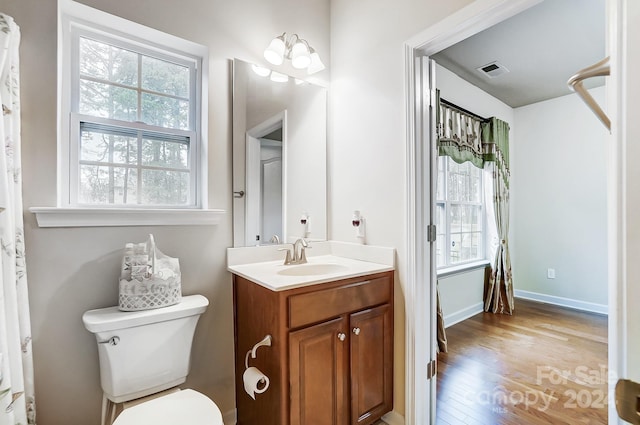 bathroom with a chandelier, hardwood / wood-style floors, vanity, and toilet