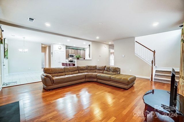 living room featuring light hardwood / wood-style floors and an inviting chandelier