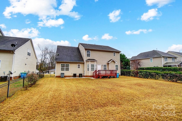 rear view of house featuring a yard and a deck