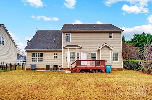 back of property with a yard, a wooden deck, and central AC