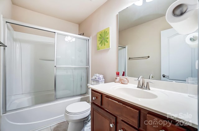 full bathroom featuring tile patterned floors, toilet, combined bath / shower with glass door, and vanity