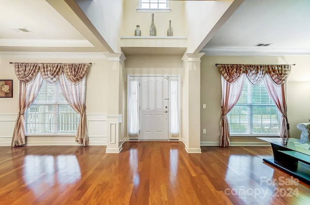 entryway with crown molding and wood-type flooring