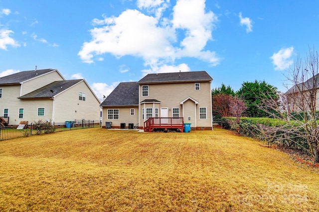 rear view of property featuring a lawn and a deck