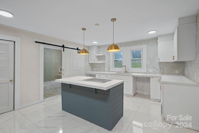 kitchen with white cabinets, pendant lighting, a barn door, and a kitchen island