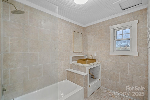 bathroom featuring tiled shower / bath combo and tile walls