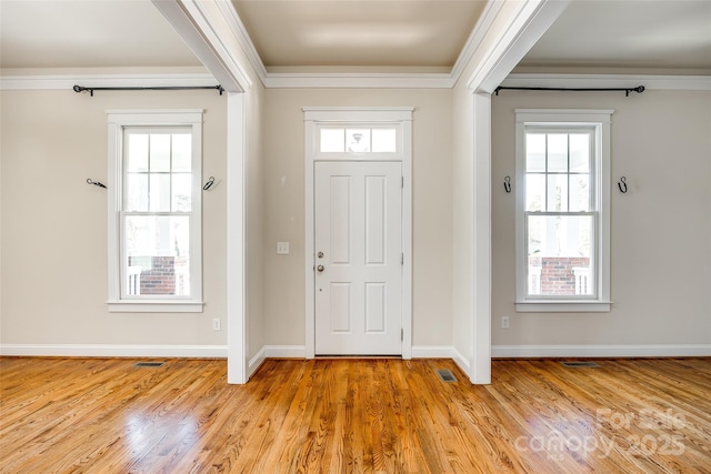 entrance foyer featuring crown molding and light hardwood / wood-style floors