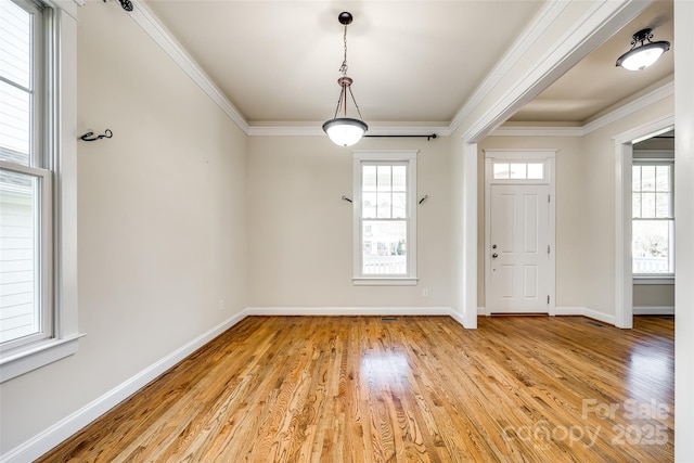 foyer featuring a healthy amount of sunlight, crown molding, and light hardwood / wood-style flooring