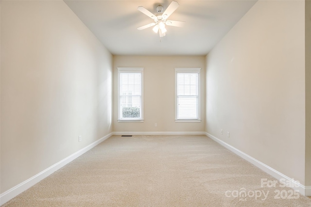 empty room with ceiling fan and light colored carpet