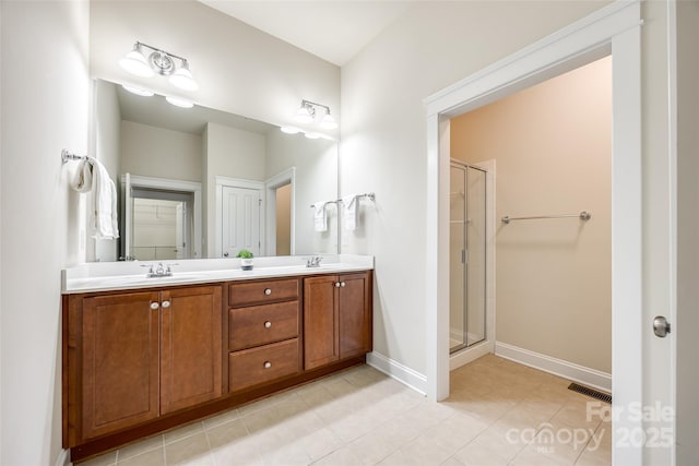 bathroom featuring tile patterned flooring, vanity, and a shower with shower door