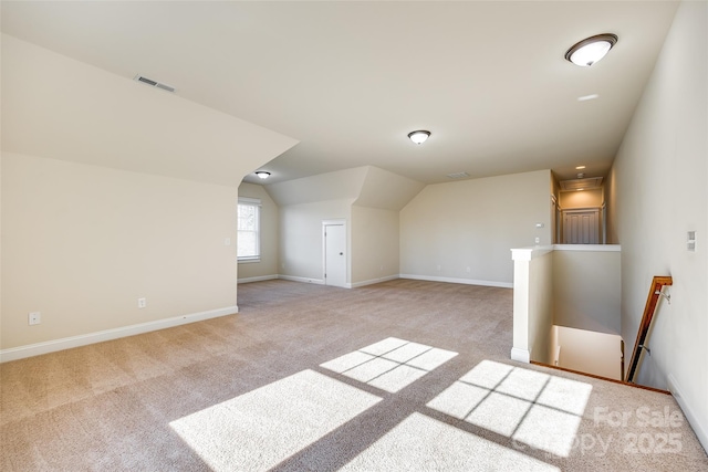 bonus room featuring light carpet and vaulted ceiling