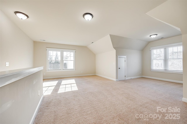 bonus room featuring plenty of natural light, light carpet, and vaulted ceiling