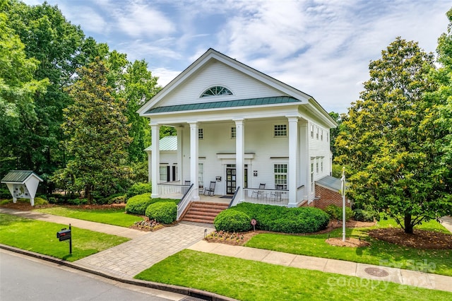 greek revival house featuring a front yard