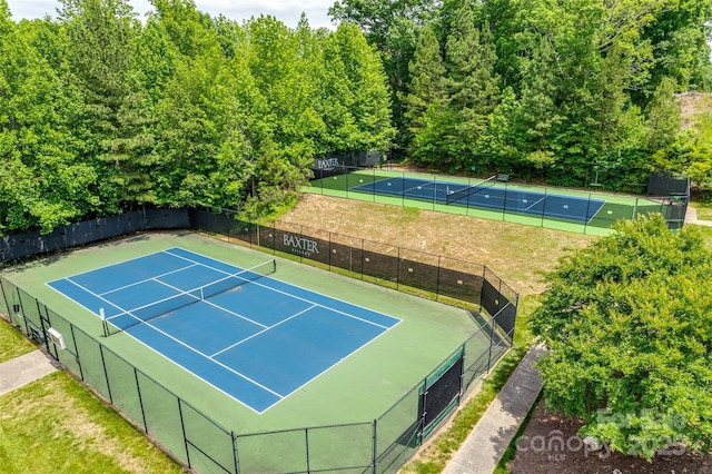 view of sport court with basketball hoop and a yard