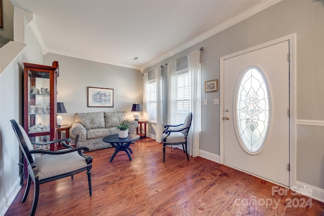 foyer entrance featuring hardwood / wood-style floors, ornamental molding, and a healthy amount of sunlight