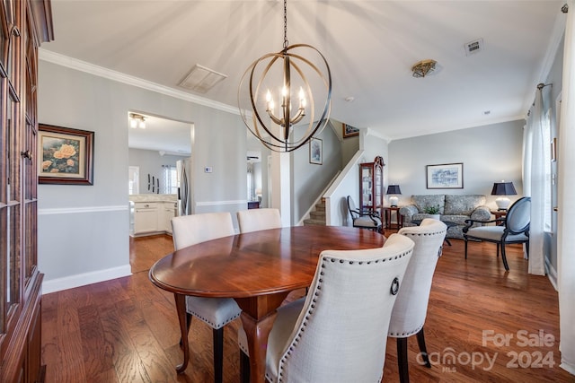 dining room with hardwood / wood-style floors, crown molding, and a chandelier