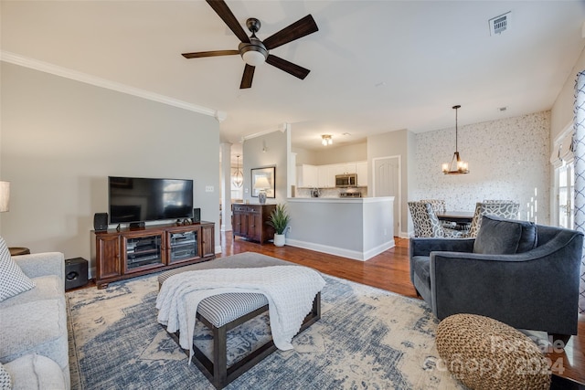 living room with hardwood / wood-style floors, ceiling fan, and ornamental molding