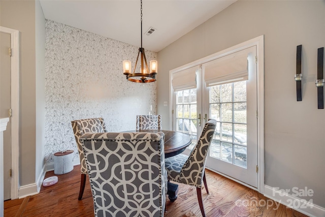 dining space featuring hardwood / wood-style flooring and an inviting chandelier