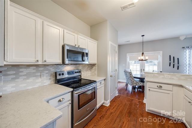 kitchen featuring white cabinets, dark hardwood / wood-style floors, backsplash, and stainless steel appliances