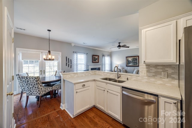 kitchen with dark wood-type flooring, white cabinets, sink, appliances with stainless steel finishes, and kitchen peninsula