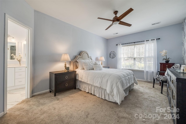 bedroom with ceiling fan, ensuite bathroom, and light colored carpet