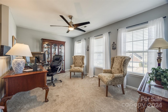 carpeted office with ceiling fan and a healthy amount of sunlight