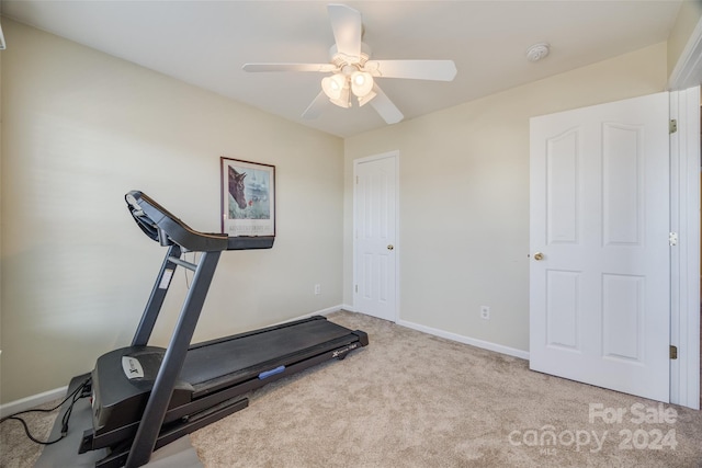 workout room featuring ceiling fan and light colored carpet