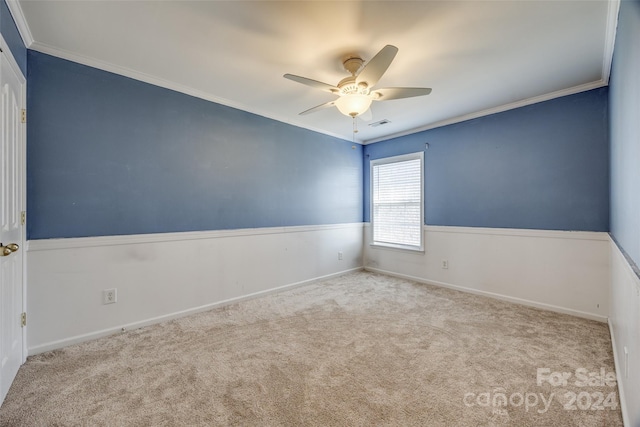 carpeted empty room with ceiling fan and crown molding